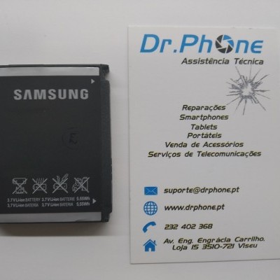 Bateria Samsung preta ao lado de cartão de visita Dr.Phone Assistência Técnica