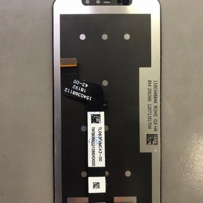 Ecrã de smartphone com etiquetas e cabos flex sobre superfície cinzenta