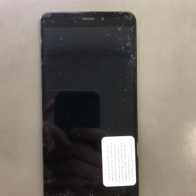 Smartphone preto com autocolante branco no ecrã