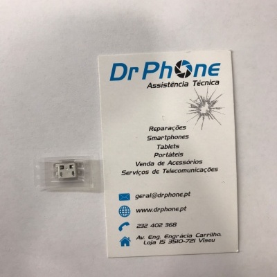 Pequeno componente eletrônico branco em embalagem plástica junto a cartão de visita da Dr Phone