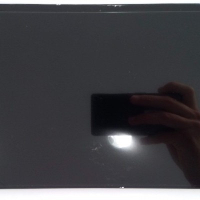 Ecrã retangular preto brilhante refletindo mão com telemóvel