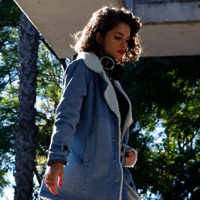 Mulher com casaco azul claro forrado com lã branca ao ar livre