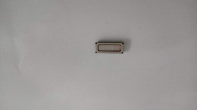 Peça eletrónica retangular cinzenta sobre folha branca