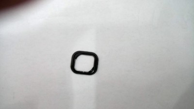 Peça metálica preta quadrada sobre fundo branco