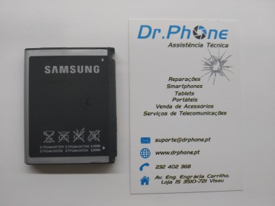 Bateria Samsung preta ao lado de cartão de visita Dr.Phone Assistência Técnica
