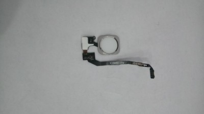 Peça eletrônica preta com componente circular branco e fita flexível preta com texto branco em fundo branco.