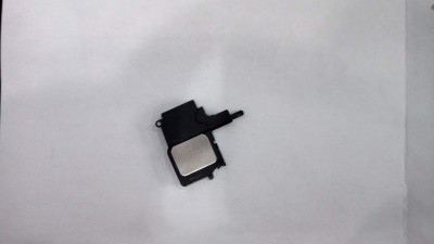 Peça eletrónica preta com componente metálico retangular sobre fundo branco