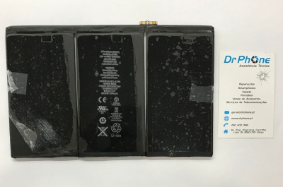 Bateria preta de smartphone com texto e símbolos, ao lado de cartão de visita da DrPhone