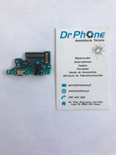 Placa eletrónica azul ao lado de cartão de visita branco com texto azul