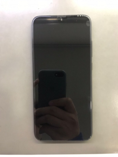 Smartphone com ecrã preto e moldura cinzenta em superfície branca