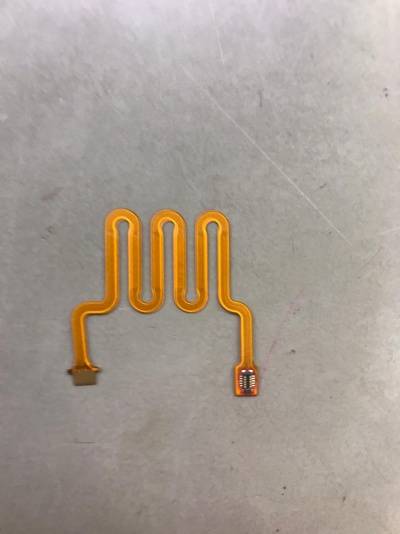 Cabo flexível amarelo com padrão ondulado e componentes eletrónicos nas extremidades