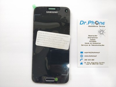 Smartphone Samsung preto com etiqueta e cartão de visita de uma assistência técnica