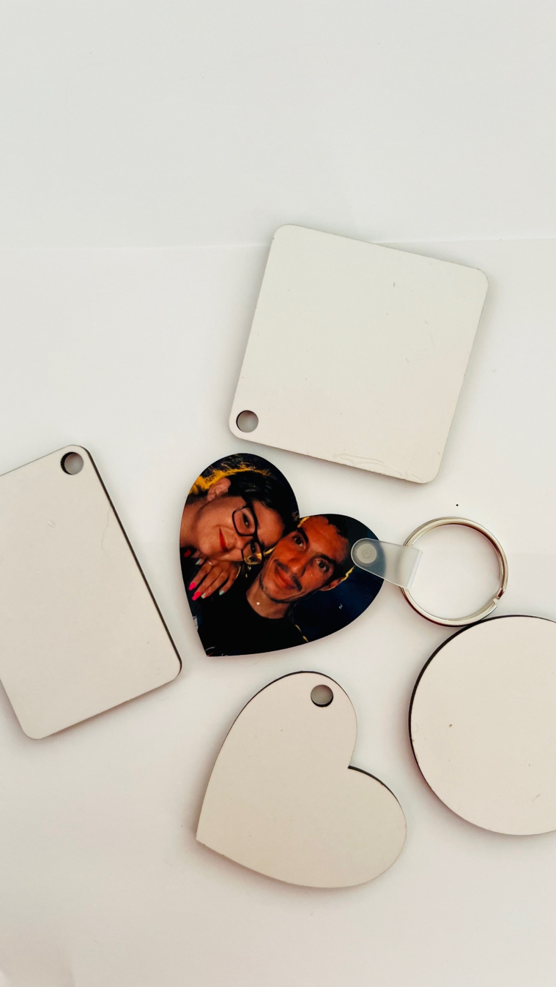 Porta-chaves de várias formas com superfícies brancas e um com fotografia de casal em forma de coração