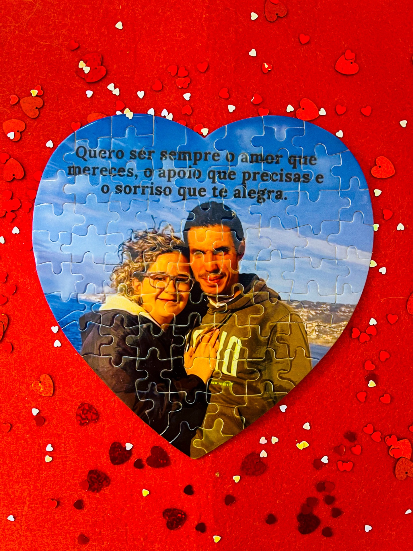 Puzzle coração com casal e texto em português sobre fundo vermelho com corações
