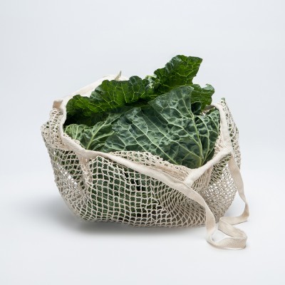 Maço de couve verde em saco de malha branco
