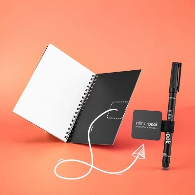 Caderno espiral Infinibook aberto com caneta preta, fundo laranja