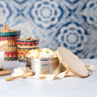 Recipiente em aço inox com tampa de madeira e arroz com legumes