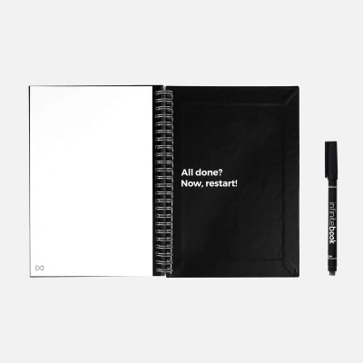 Caderno com capa preta e texto branco e caneta preta ao lado