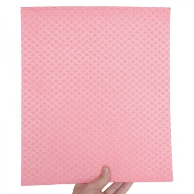 Pano de limpeza rosa com padrão de losangos segurado por uma mão