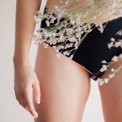 Parte inferior do corpo com roupa íntima preta e flores pequenas
