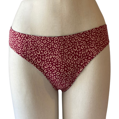 Cuecas femininas vermelhas com padrão de manchas claras em manequim branco