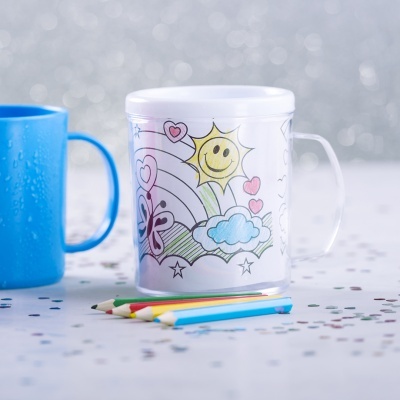 Caneca transparente com ilustração para colorir e lápis de cor ao lado