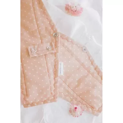 Casaco bege com bolinhas brancas, botões de pressão metálicos e etiqueta 