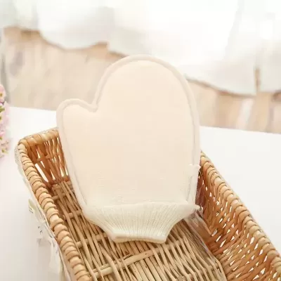 Luva esfoliante branca dentro de cesta de vime