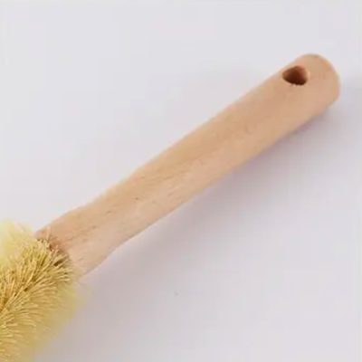 Escova de limpeza com cabo de madeira clara e fibras naturais