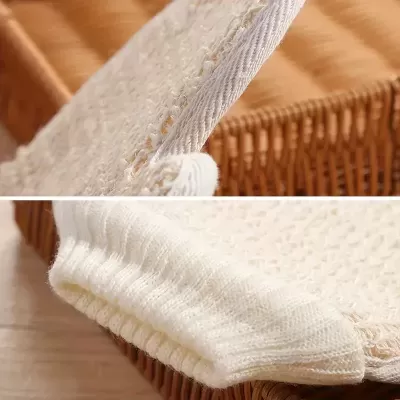 Tecido branco em malha com textura aberta sobre cesta de vime castanho claro