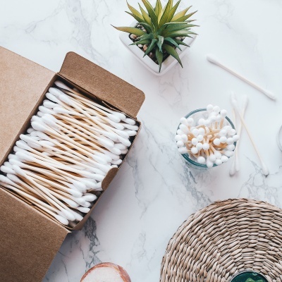 Caixa de algodões e planta suculenta num ambiente com base de mármore e palha