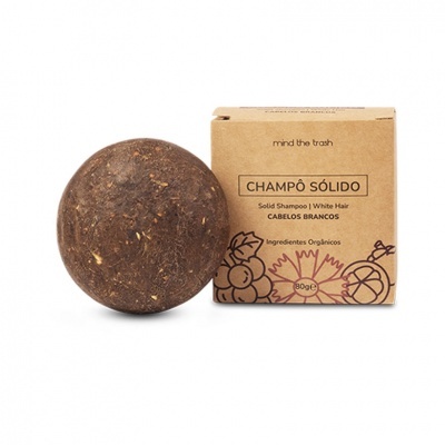 Champo sólido castanho redondo ao lado da embalagem castanha com texto e desenhos florais