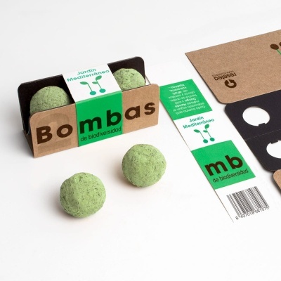 Caixa com duas bolas verdes de biodiversidade em embalagem de cartão reciclado