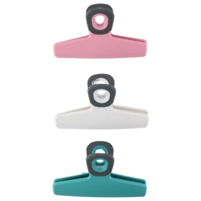 Três molas de cozinha coloridas: rosa, branca e verde com detalhes pretos