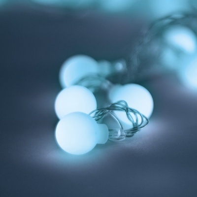 Cordão de luzes com bolas azuis brilhantes em superfície lisa