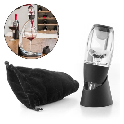 Aerador de vinho em plástico transparente e preto com suporte e saco de veludo preto, colocado sobre superfície de madeira.