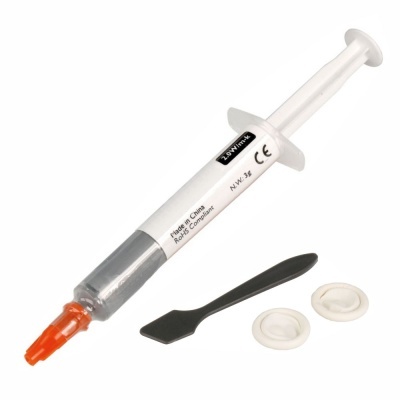 Seringa plástica com pasta térmica cinzenta, espátula preta e duas peças brancas