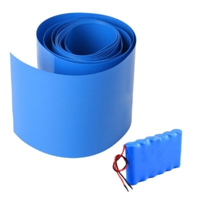 Fita azul enrolada e pacote de baterias azul com fios sobre fundo branco