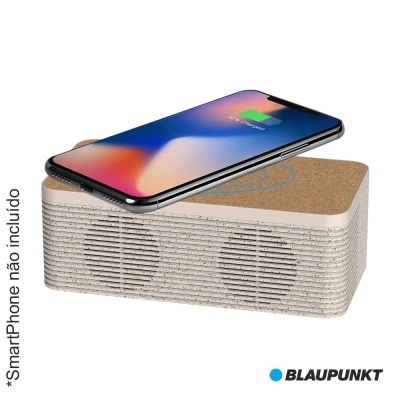 Base de carregamento sem fios e altifalante Bluetooth Blaupunkt bege e branco com textura de cortiça e texto sobre smartphone não incluído.
