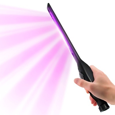 Bastão preto a emitir luz roxa na mão de uma pessoa