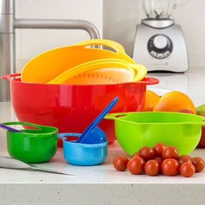 Conjunto de tigelas e escorredores coloridos numa bancada de cozinha