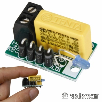 Módulo eletrónico compacto com condensador amarelo e LED azul segurado por mão sobre fundo branco.