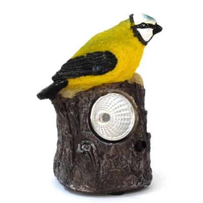Decoração de jardim com pássaro amarelo e preto sobre tronco com luz LED