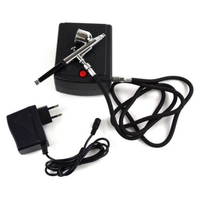 Kit de aerógrafo com compressor, pistola metálica e adaptador de tomada.