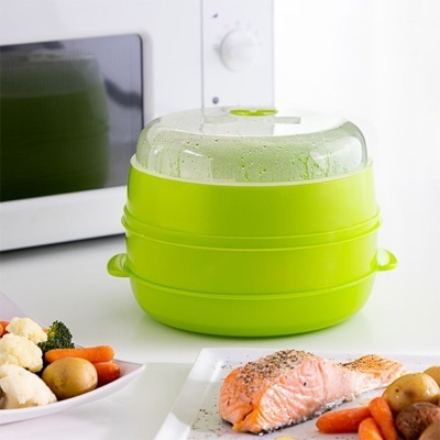 Recipiente verde para cozinhar a vapor com tampa transparente na bancada de cozinha