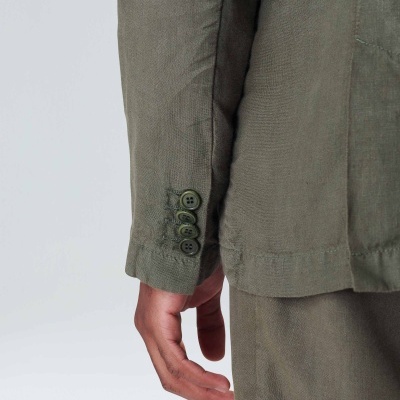 Braço com casaco verde-oliva e botões no punho