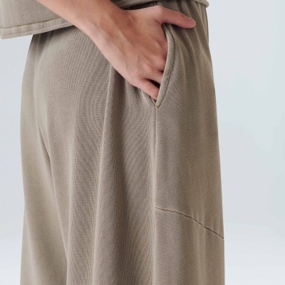 calças largas bege com bolso lateral e mão inserida