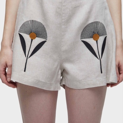 Calções bege claro com bordado de flores pretas e amarelas