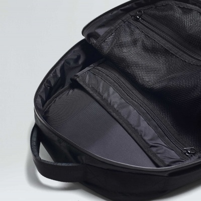 Mochila preta aberta mostrando vários bolsos internos com fechos