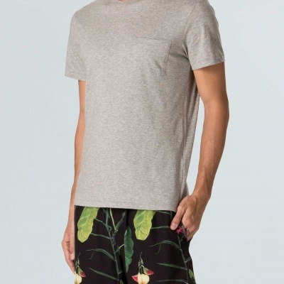 Homem a usar t-shirt cinza clara e calções pretos com padrão floral colorido